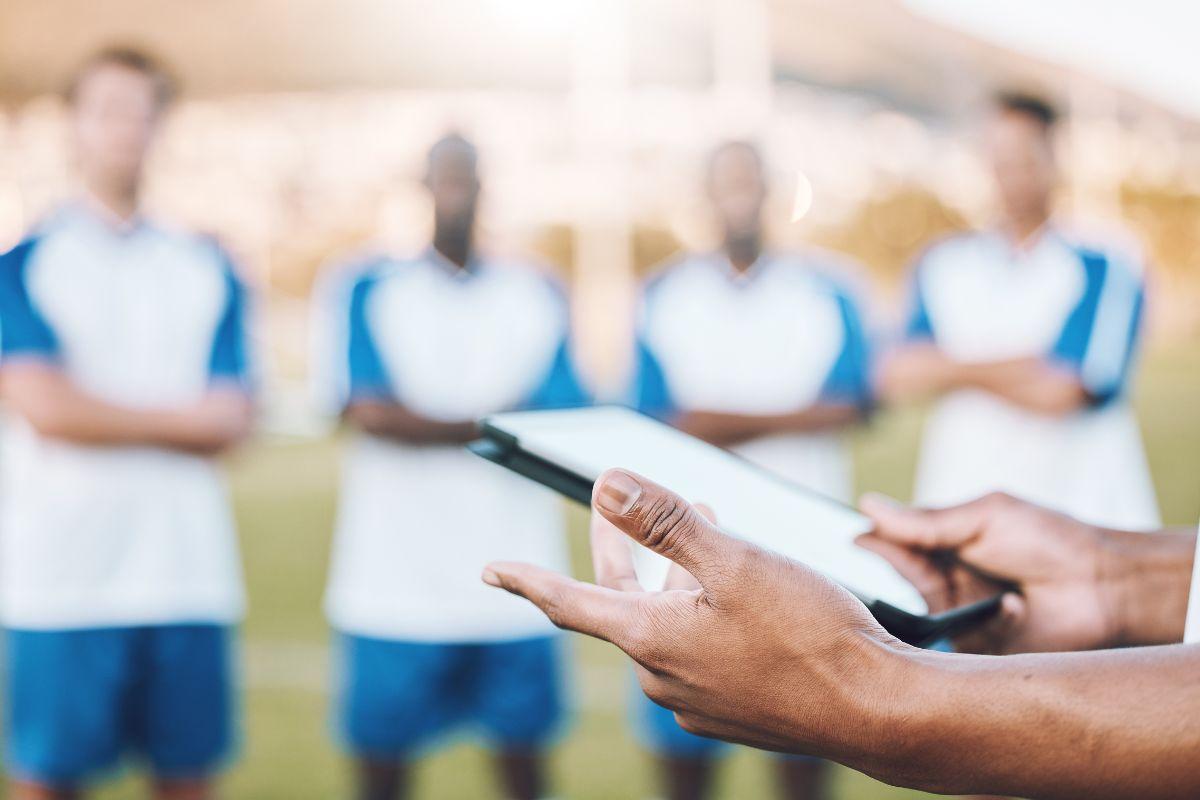 a coach holds an ipad during a team huddle