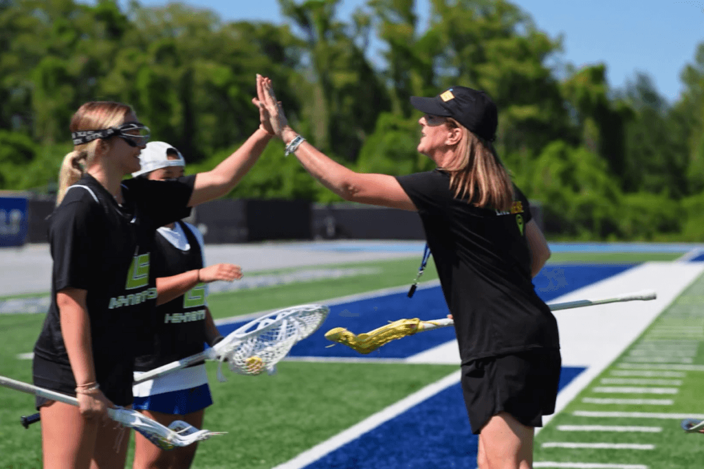 an isnation coach high fives a player in an isnation uniform